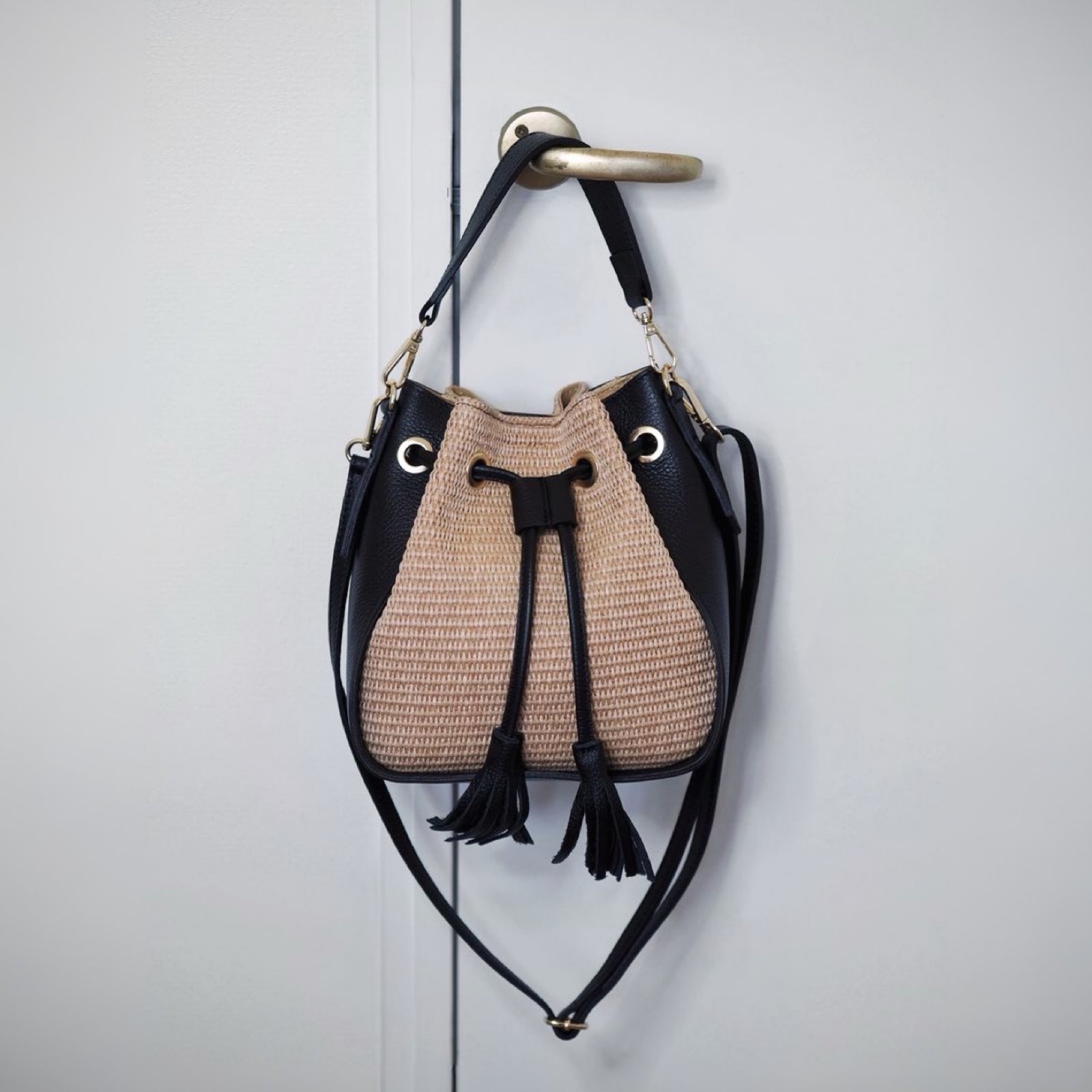 Bucket bag i raffia med svarte skinndetaljer