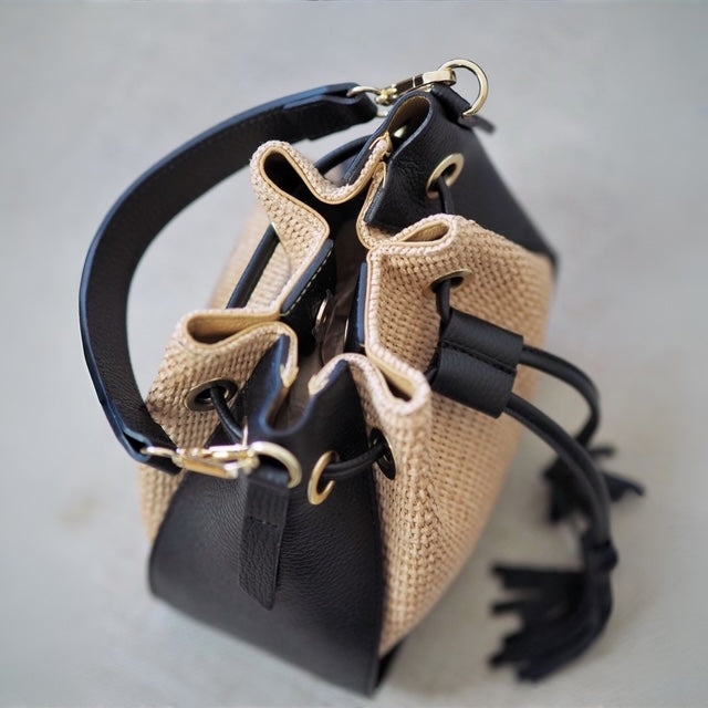 Bucket bag i raffia med svarte skinndetaljer